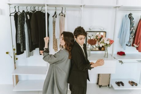 A Mother and Son Standing Back to Back while Fixing their Clothes